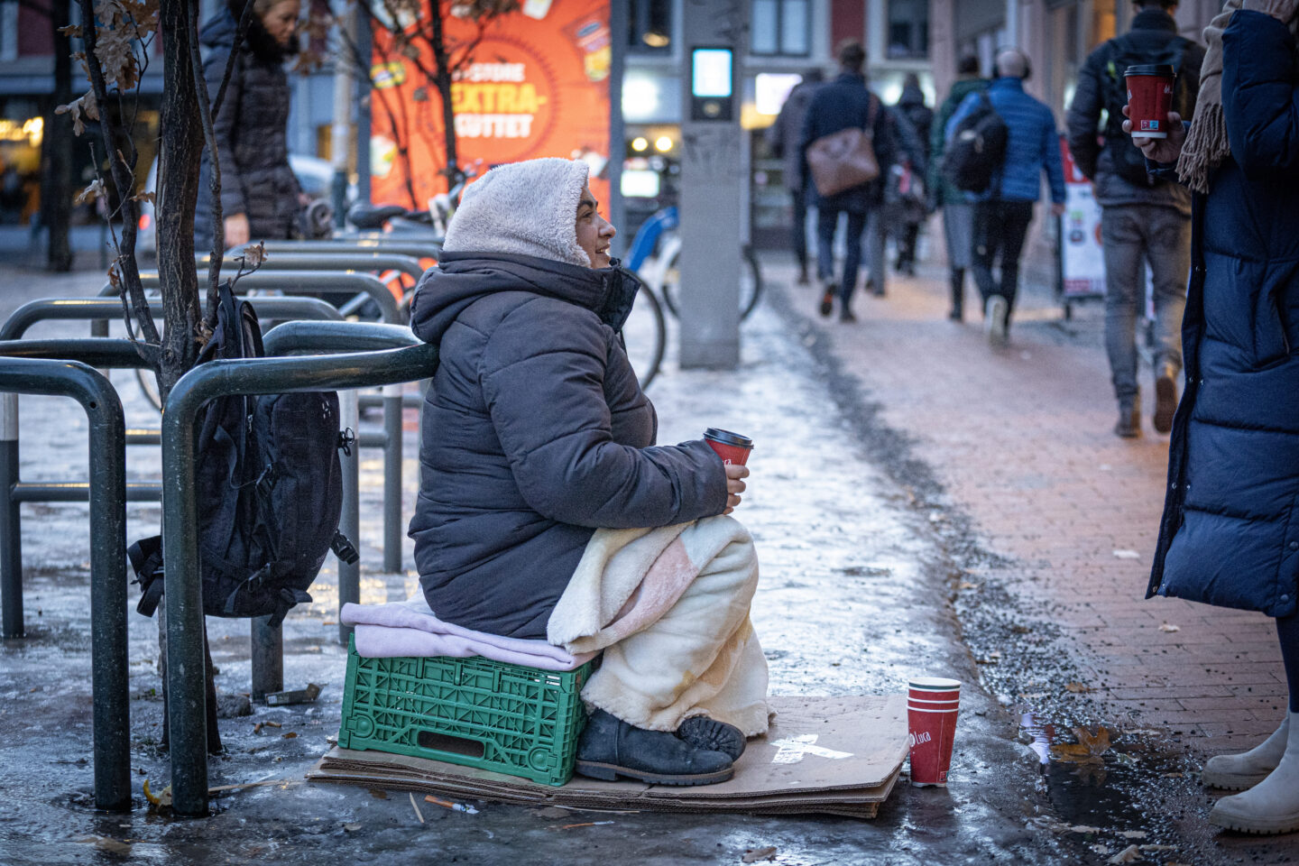 Kvinne som sitter p&aring; gata