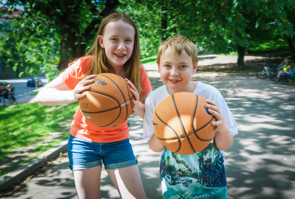 Jente og gutt med basketball utend&oslash;rs