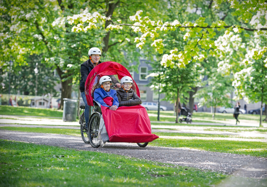 Eldre i sykkelvogn p&aring; sykkeltur med ansatt