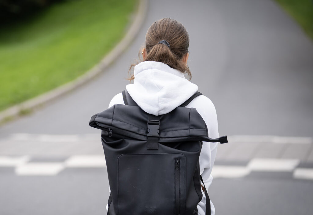 Illustrasjonsfoto av jente alene p&aring; vei til skolen med sekk. 