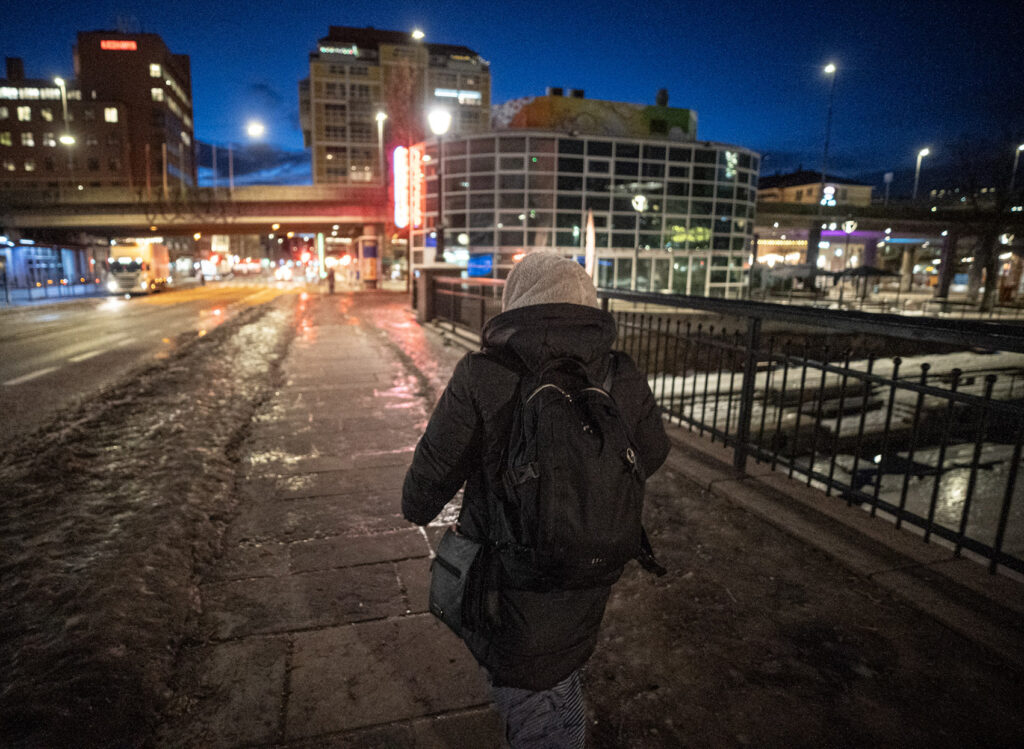 Kvinne som g&aring;r ute p&aring; gata sent p&aring; kvelden