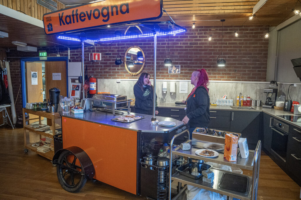 Innsiden av kaf&eacute;en med kaffevogn